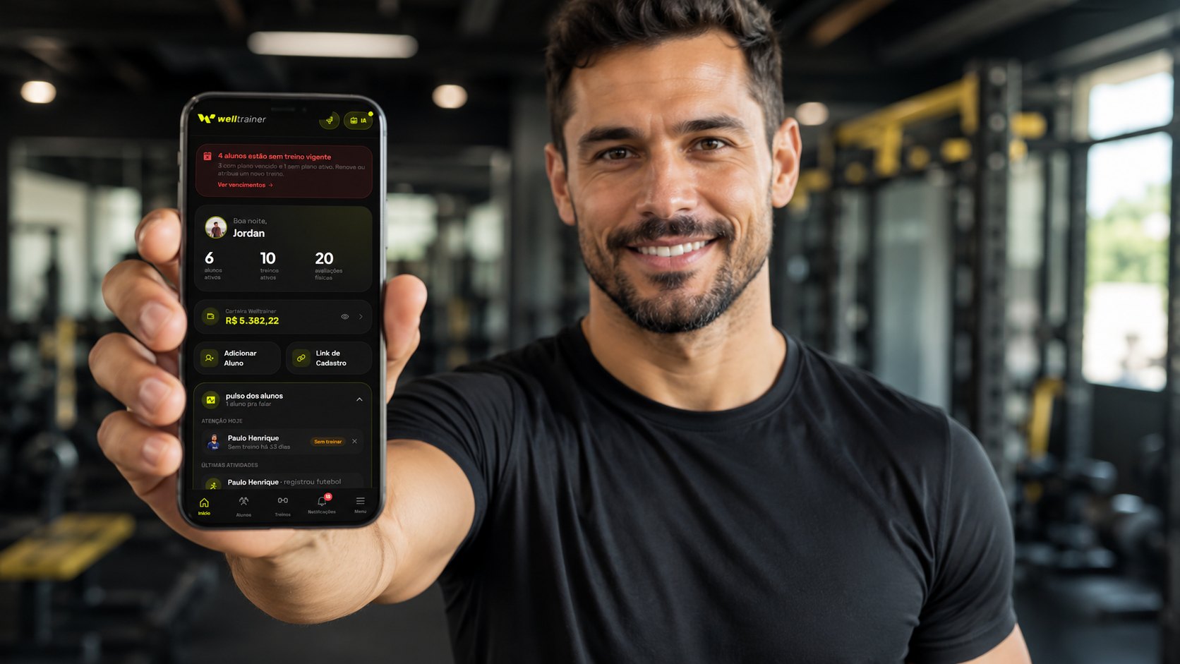 Personal trainer mostrando o app Welltrainer no celular numa academia
